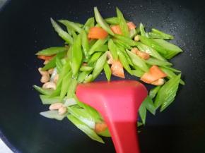 再另外倒适量油，下西芹之类的进去翻炒。因为西芹是焯熟的，胡萝卜是片，所以炒个二分钟也就熟了。八分熟的时候放虾仁进去，然后加点盐调味。