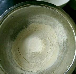 玉米油和牛奶混合，搅打至乳化。筛入低筋面粉，搅拌均匀。