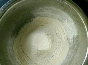 玉米油和牛奶混合，搅打至乳化。筛入低筋面粉，搅拌均匀。