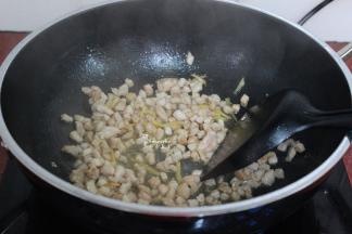 热锅倒油，放生姜、瘦肉粒爆炒熟起锅；