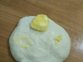 然后用手和成团，用力揉到初步扩展时加入黄油。继续用力揉、揉、揉……
