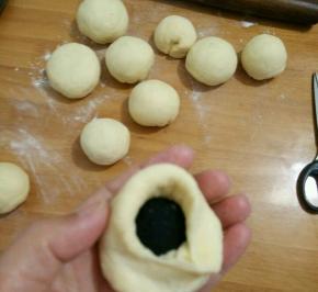 取个剂子擀开，放上适量芝麻馅，包好再搓圆。
