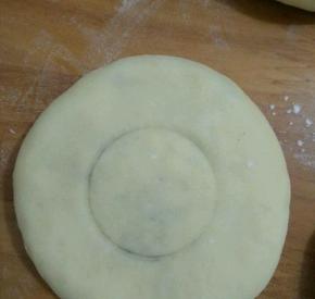 用手掌或是擀面杖轻轻压一下，成个圆饼。找个矿泉水盖在中间压出痕迹。