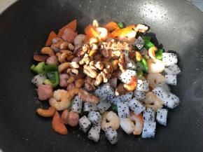 放入火龙果和核桃仁，腰果炒匀即可
