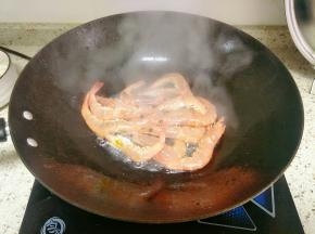放入腌制好的明虾大火翻炒，半炸至酥脆捞出沥油