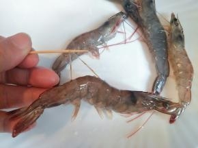 明虾背后剪开，用牙签挑去沙线，剪掉须脚