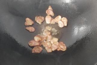 锅中入少许油放入腊肠煸炒一下，炒至腊肠微黄出油
