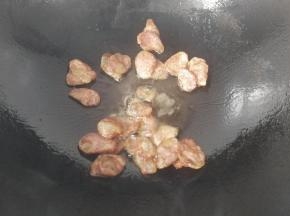 锅中入少许油放入腊肠煸炒一下，炒至腊肠微黄出油