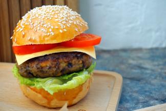 然后依次放入生菜、煎好的肉饼、芝士片、番茄、盖上汉堡胚子