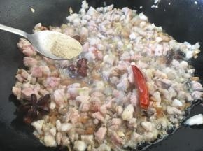 滑炒肉粒至颜色变色，放入少许的白胡椒粉，翻炒几下。
