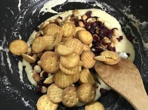 倒入花生、蔓越莓干和小圆饼干。