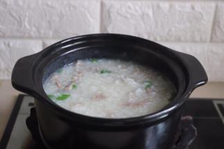 待米粥煮至浓稠放入肉丝（去除腌制的葱、姜片）和葱花，用筷子搅拌开肉丝