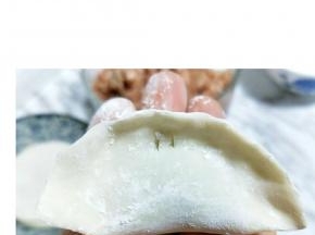 将饺子皮对折，再将两边捏紧。