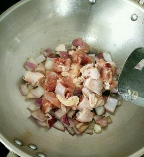 下鸡腿肉和少许料酒，继续翻炒。