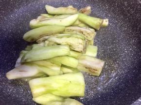 热锅下油，油温七成时放入茄子