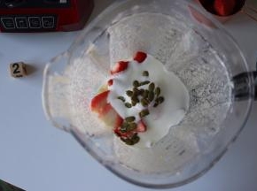 草莓同酸奶、南瓜子一起放入搅拌杯内；