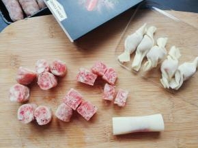 把香肠段包入馄饨皮中沾点清水沾合住封口，拧成糖果状