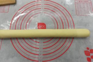 把发酵好的面团取出挤压排气后静置15分钟，然后搓成长圆条