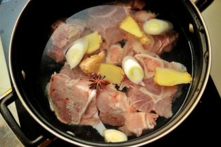 洗净的骨头冷水入锅，加入八角、葱段和姜片，烧开后大火煮几分钟，用勺子撇去表面的黑色浮沫，等汤变清爽，浮沫变成白色就可以了。