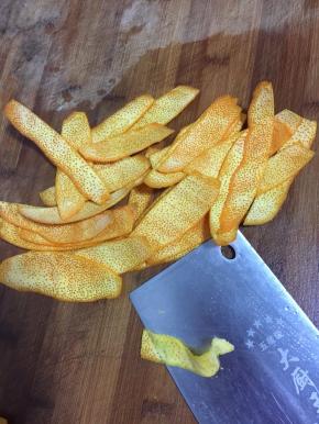 再用刀把橙皮白色的部分削干净。（一定要把白色的部分彻底清理干净哦，要不然做出来的糖会发苦。）