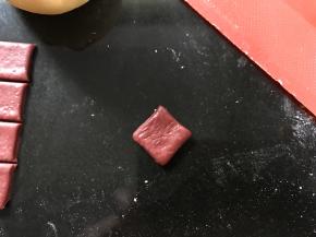 再把红色面团擀成薄面片，切割菱形状。