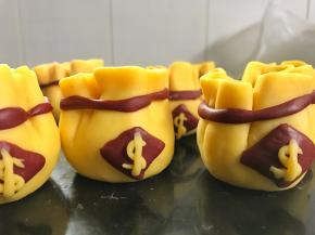 再用一小块南瓜面团搓成条状做成钱符号贴在红色菱形片上。