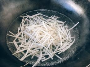 锅里的水开了后放入2滴油，放入绿豆芽焯水，焯水后捞出过凉水，沥干水分备用。