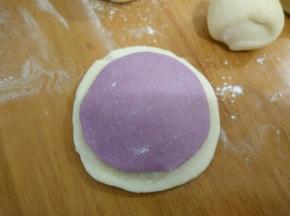 分别取个白色和紫色面团，擀成中间厚旁边薄。然后在中间抹点水，把两块沾在一起。