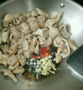 锅里先不放油下大肠，慢火炒干水份。把大肠推到旁边，加入油和辣椒、蒜头。