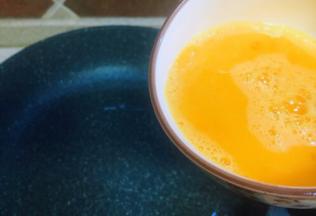 取平底锅，中高火，热锅倒入葵花油，待油温7成时倒入调好的鸡蛋液