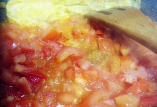 炒至西红柿丁出汁软烂，把蛋和西红柿合在一起炒均匀