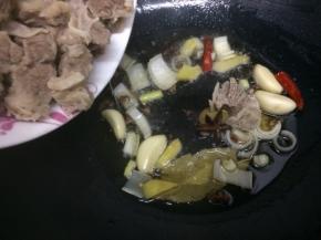 在把牛腩放入锅中翻炒片刻
