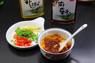 取出20克香菇酱；倒入3ml的麻油在香菇酱碗拌均；辣椒、香葱、生姜是分成洗净切好，酱料也调制好；
