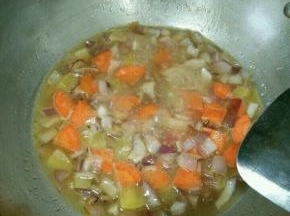 煸炒均匀后加入热水，没过食材。煮到胡萝卜和土豆熟。
