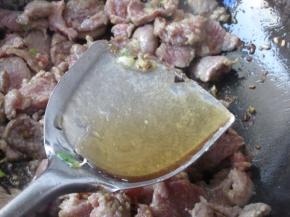 翻炒至稍微变色，但还有红色的时候，烹入黄酒，黄酒要沿着锅边烹入