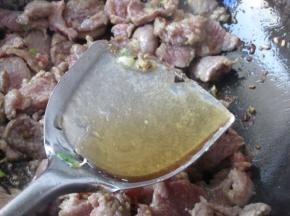 翻炒至稍微变色，但还有红色的时候，烹入黄酒，黄酒要沿着锅边烹入