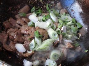 孜然粉翻炒均匀就可以关火，同时加入剩余的葱，利用余温翻炒，让葱熟就行了。