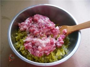 酸菜挤干水分，切碎放入盆中、倒入猪肉馅