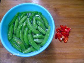 将甜豆浸泡片刻，洗净后捞起，红辣椒洗净切片