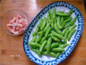 瘦肉洗净切丝，调入盐、鱼露抓匀入味，再调入淀粉拌匀，腌制片刻，撕去甜豆经络