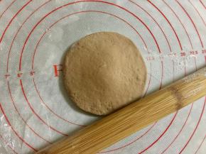 取其中一小份可可面团，搓圆按扁，擀成圆形。