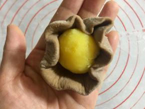把奶黄馅揉成15克左右的球，包进面皮里。