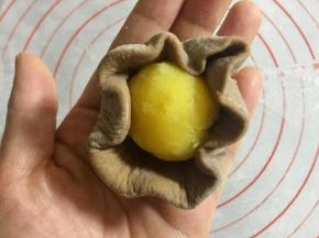 把奶黄馅揉成15克左右的球，包进面皮里。