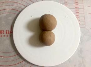 同样的方法再包一个奶黄包，包入20克左右的馅，稍微大一点。两个奶黄包放在一起，大的做脑袋，小的做身体。