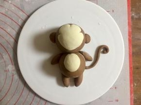 最后揉一条可可面团细条，做猴子的尾巴，连接到相应的位置。