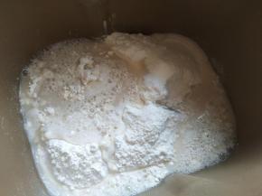 先把酵母倒入温水里溶解，中筋面粉、细砂糖倒入面包桶，再倒入酵母水