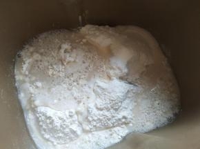 先把酵母倒入温水里溶解，中筋面粉、细砂糖倒入面包桶，再倒入酵母水