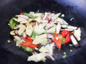 放入青红椒、冬笋、香菇、少许的白胡椒粉迅速翻炒。