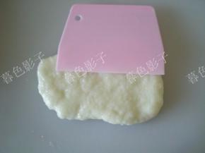 取一块揉好的糯米面团，用抹油的刮刀按压平整