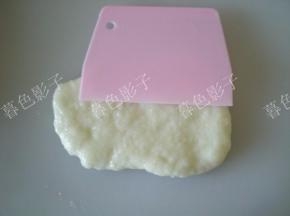 取一块揉好的糯米面团，用抹油的刮刀按压平整